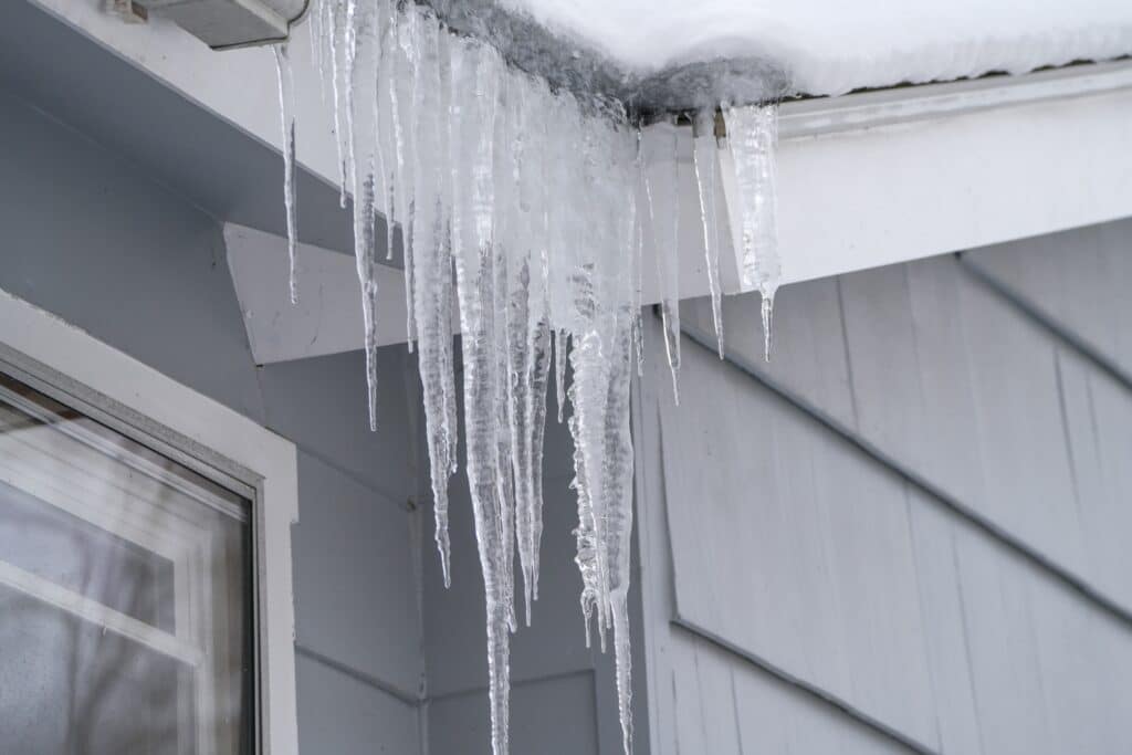 winter house with icicle and snow on the roof